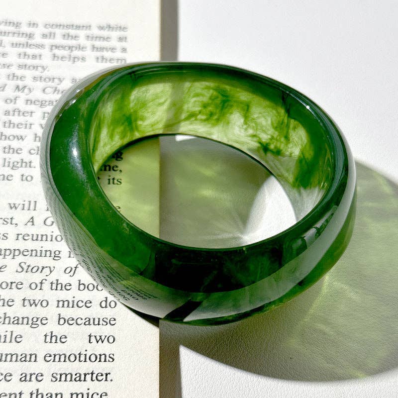 Green bangle on a book with a white background