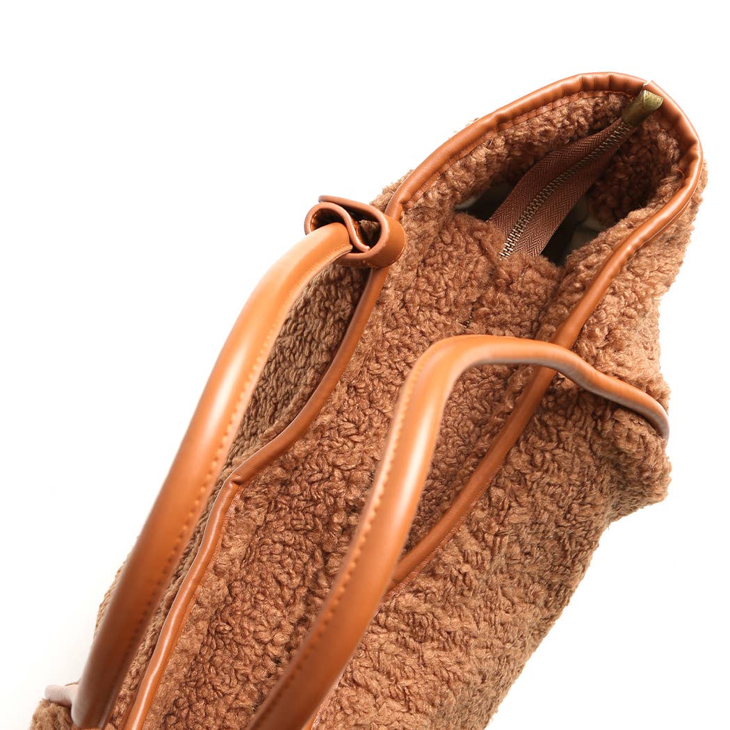 Brown teddy bear-like shoe with a zipper on a white background