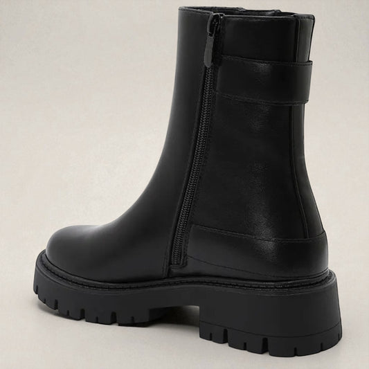 Black rubber boot with a thick sole on a light gray background