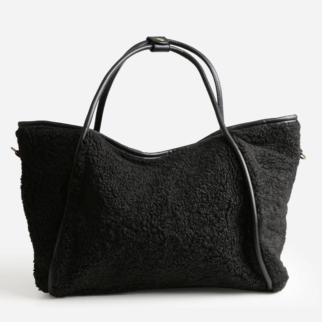 Black shearling handbag on a white background