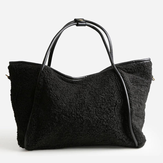 Black shearling handbag on a white background