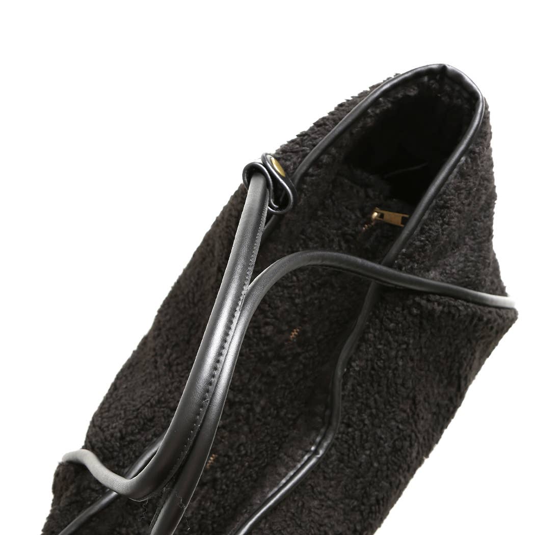 Black textured handbag with a strap on a white background