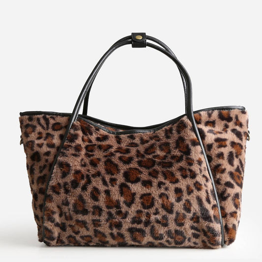 Leopard print handbag with black handle on a white background