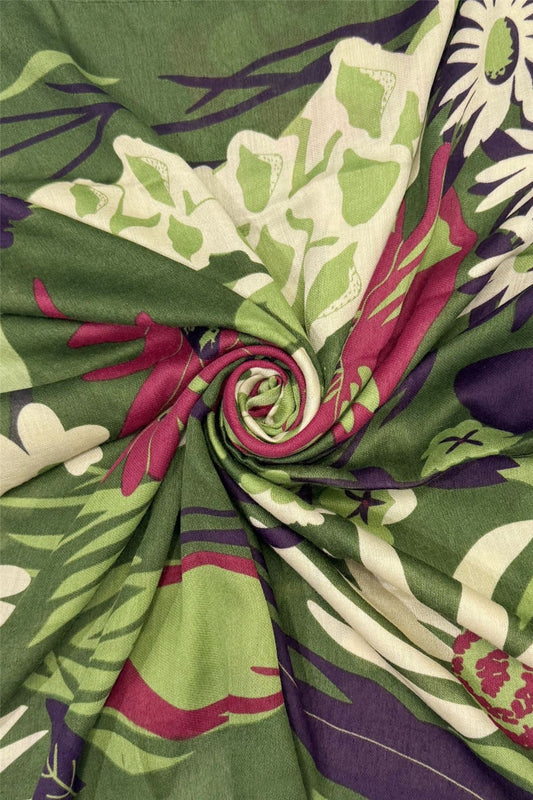 Close-up of a folded fabric with a floral pattern in green, purple, and white.