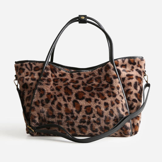 Leopard print handbag with black handle and strap on a white background