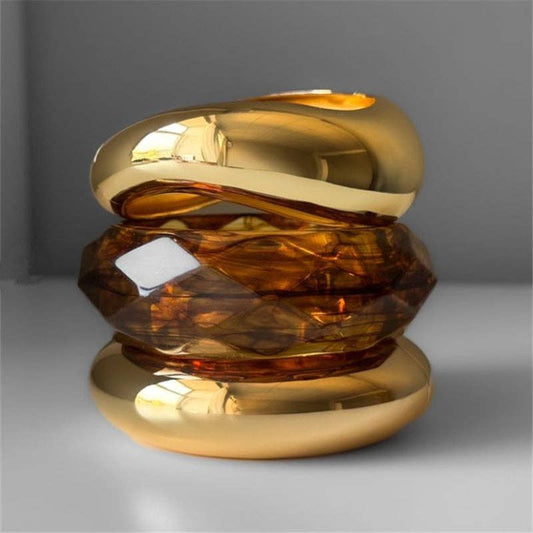 Gold and amber Bracelets on a gray background