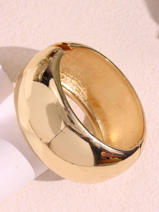 Gold bracelet on a light pink background