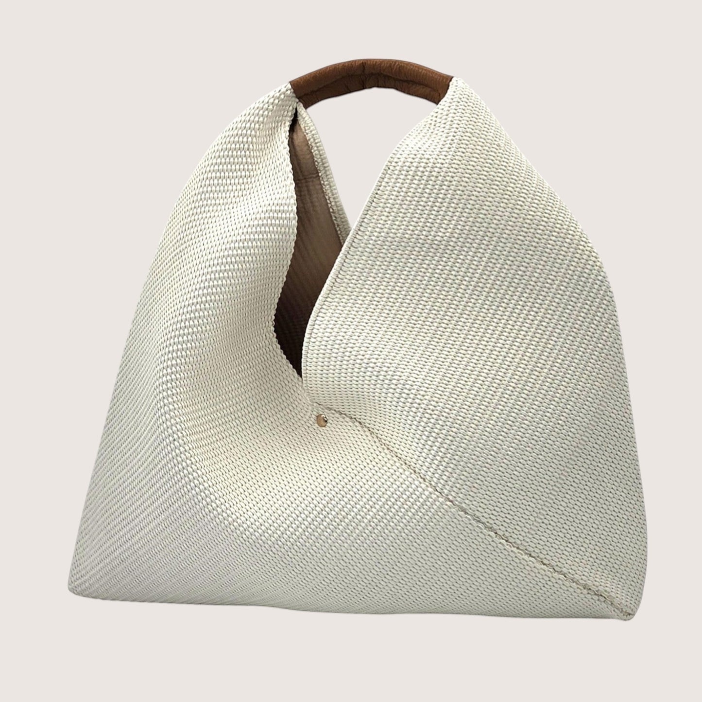 Feather & Sole beige woven shoulder bag with a brown leather handle and a slouchy silhouette.