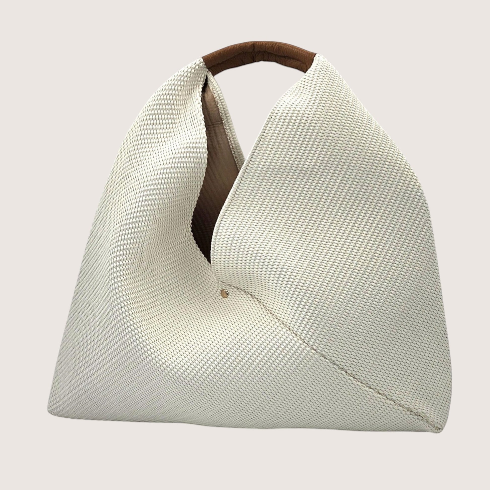 Feather & Sole beige woven shoulder bag with a brown leather handle and a slouchy silhouette.