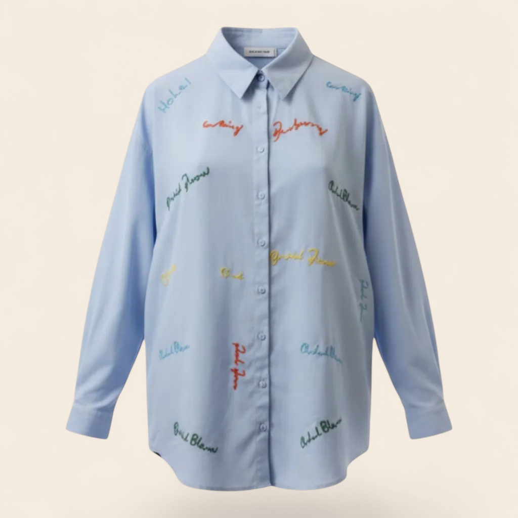 Feather & Sole light blue cotton blend long-sleeved shirt with colorful embroidered text details and classic collar.